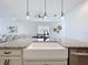 Farmhouse sink with granite countertops, white cabinetry, and modern faucet, offering a stylish workspace at 15727 Vetta Dr, Montverde, FL 34756