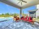 Covered patio features comfortable lounge furniture with a ceiling fan overlooking the pool and backyard at 15727 Vetta Dr, Montverde, FL 34756