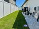 Landscaped backyard with white fence and equipment concealed by gravel, and lush green grass at 2075 Huntsman Ridge Rd, Clermont, FL 34715