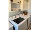 Bright laundry room featuring modern Samsung machines, storage cabinets, open shelving, and vinyl flooring at 2075 Huntsman Ridge Rd, Clermont, FL 34715