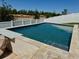 Backyard pool with a modern design, set in a well-manicured lawn and privacy fence at 2075 Huntsman Ridge Rd, Clermont, FL 34715