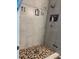 Bright shower with stylish stone-look tile and mosaic tile floor with sleek fixtures, providing a luxurious feel at 2075 Huntsman Ridge Rd, Clermont, FL 34715
