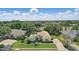 Aerial view of single-story home with lush landscaping, palm trees, and a tile roof within a neighborhood at 216 Hammock Oak Cir, Debary, FL 32713