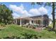 Lush green lawn with landscaping leading to a screened-in pool and patio at 216 Hammock Oak Cir, Debary, FL 32713