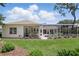 Well-manicured lawn and landscaping lead to a screened-in pool and patio area at 216 Hammock Oak Cir, Debary, FL 32713