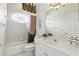 Well-maintained bathroom with a tub/shower combo, oval window, and neutral finishes at 216 Hammock Oak Cir, Debary, FL 32713