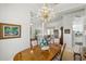 An open dining room with a wood table and chandelier, connecting the living spaces within the home at 216 Hammock Oak Cir, Debary, FL 32713