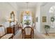 Bright dining room features a chandelier, wooden table with chairs, and a window with natural light and custom window treatments at 216 Hammock Oak Cir, Debary, FL 32713