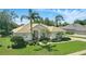 Single-story home with lush landscaping, palm trees, and a tile roof under a sunny sky at 216 Hammock Oak Cir, Debary, FL 32713