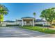 Exterior of the clubhouse featuring covered entrance, mature landscaping and ample parking at 216 Hammock Oak Cir, Debary, FL 32713