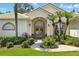 Close up on the double front door with wreaths, surrounded by lush landscaping and palm trees at 216 Hammock Oak Cir, Debary, FL 32713