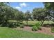 Lush green lawn with trees and landscaping, backing up to a golf course view at 216 Hammock Oak Cir, Debary, FL 32713