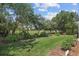 A lush green lawn with trees and landscaping, backing up to a golf course at 216 Hammock Oak Cir, Debary, FL 32713