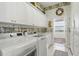 Bright laundry room with modern appliances, ample cabinet space, and decorative wallpaper at 216 Hammock Oak Cir, Debary, FL 32713