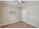 Bright bedroom featuring hardwood floors, neutral paint, ceiling fan, and natural light from the window at 246 N Oak Ave, Orange City, FL 32763