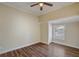 Bright bedroom featuring hardwood floors, neutral paint, ceiling fan, and natural light from the window at 246 N Oak Ave, Orange City, FL 32763