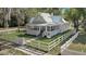 Charming home with a welcoming front porch, gray siding, metal roof, and white picket fence enhancing curb appeal at 246 N Oak Ave, Orange City, FL 32763