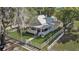 Attractive home featuring a cozy front porch, gray siding, metal roof, and picturesque white picket fence at 246 N Oak Ave, Orange City, FL 32763