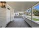 Classic front porch with gray flooring, a porch railing, and a view of a charming street at 246 N Oak Ave, Orange City, FL 32763