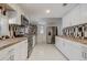 Updated kitchen featuring stainless steel appliances, white cabinets, and unique backsplash at 246 N Oak Ave, Orange City, FL 32763