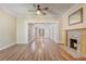 Bright living room features a decorative fireplace, wood floors, ceiling fan and natural light at 246 N Oak Ave, Orange City, FL 32763