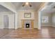 Cozy living room with wood flooring, a fireplace with stone accents, and a ceiling fan at 246 N Oak Ave, Orange City, FL 32763