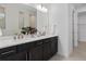 Bathroom features dual sinks, dark wood cabinets, and contemporary fixtures at 2741 Serenity Meadow Dr, Kissimmee, FL 34744