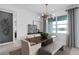 Dining area features a wooden table, tufted bench, modern chandelier, and picturesque window view at 2741 Serenity Meadow Dr, Kissimmee, FL 34744