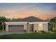 Charming single-story home with neutral stucco, brown accents, and attached two car garage at 2741 Serenity Meadow Dr, Kissimmee, FL 34744