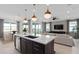 Open concept kitchen with island seating, stainless steel appliances and access to outdoor living at 2741 Serenity Meadow Dr, Kissimmee, FL 34744