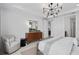 Neutral bedroom features wood accent cabinet, chandelier, plush chair and natural light at 2741 Serenity Meadow Dr, Kissimmee, FL 34744