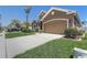 Exterior view showcasing the front yard, driveway, and two-car garage at 2827 Moonstone Bnd, Kissimmee, FL 34758