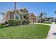 Landscaped front yard with palm trees, well-manicured lawn and exterior with a two-car garage at 2827 Moonstone Bnd, Kissimmee, FL 34758