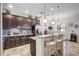 Well-lit kitchen with dark wood cabinets, granite countertops, and bar stool seating at 2827 Moonstone Bnd, Kissimmee, FL 34758