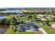 An aerial view of the home and landscaping, highlighting the surrounding community, golf course, and serene lake at 2984 Monica Ter, Kissimmee, FL 34744