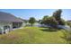 Large grassy backyard with a white fence and view of the lake from the screened in patio at 2984 Monica Ter, Kissimmee, FL 34744