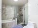 Bright bathroom featuring a bathtub with gray tile surround and glass enclosed shower with a rainfall shower head at 2984 Monica Ter, Kissimmee, FL 34744