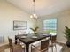 Dining room features a modern table, six chairs, stylish chandelier, and large window at 2984 Monica Ter, Kissimmee, FL 34744