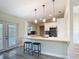 Eat-in kitchen features a large island with bar stool seating, modern pendant lights, and stainless appliances at 2984 Monica Ter, Kissimmee, FL 34744