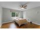 Cozy bedroom with hardwood floors, a ceiling fan, and a window providing natural light at 314 E Bonnie Trl, Longwood, FL 32750