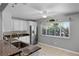 Bright kitchen featuring white cabinets, stainless steel appliances, and a window overlooking the backyard at 314 E Bonnie Trl, Longwood, FL 32750