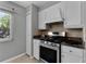 Kitchen with stainless steel gas range, granite counters, and white cabinets at 314 E Bonnie Trl, Longwood, FL 32750