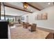 Open-concept living area featuring beamed ceilings, neutral furniture, and wood-look tile floors at 327 Island Sound Ct, Longwood, FL 32779