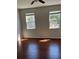Bedroom featuring hardwood floors, ceiling fan, and large windows for natural light at 3344 Corona Village Way # 205, Orlando, FL 32835