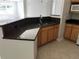 Kitchen featuring granite countertops, stainless steel sink, and wooden cabinets at 3344 Corona Village Way # 205, Orlando, FL 32835