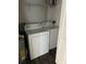 An indoor laundry room features a white washer and dryer and overhead shelving at 3344 Corona Village Way # 205, Orlando, FL 32835
