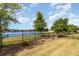 Lush backyard overlooking a serene lake, complemented by a sturdy black metal fence at 3443 Sagebrush St, Harmony, FL 34773