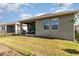 Spacious backyard with well-maintained lawn, black metal fence and covered patio with chairs at 3443 Sagebrush St, Harmony, FL 34773
