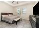 Comfortable bedroom with tray ceiling, two windows, and a dark dresser, creating a relaxing private space at 3443 Sagebrush St, Harmony, FL 34773