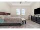 Comfortable bedroom with tray ceiling, two windows, and a dark dresser, creating a relaxing private space at 3443 Sagebrush St, Harmony, FL 34773
